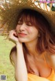 A woman in a straw hat is posing for a picture.