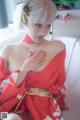 A woman in a red kimono sitting on a chair.