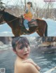 A woman sitting on top of a brown horse in the snow.