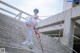 A woman in a white bodysuit is standing on some stairs.