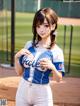 A woman in a baseball uniform standing on a baseball field.